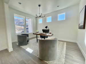 Home office featuring light wood-type flooring, an inviting chandelier, baseboards, and recessed lighting