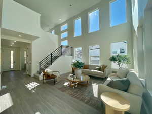 Living area with recessed lighting, stairway, baseboards, and wood finished floors