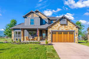 Craftsman inspired home with board and batten siding, a garage, a porch, and a front lawn