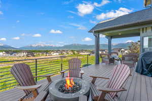 Wooden terrace with an outdoor fire pit, a residential view, and a mountain view