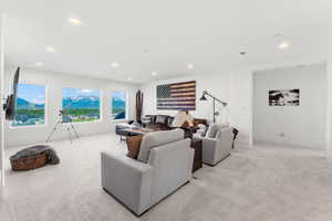 Living area with recessed lighting, visible vents, baseboards, and light colored carpet