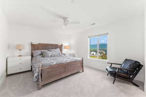 Bedroom featuring ceiling fan, visible vents, and light colored carpet