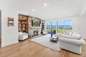 Living room with light wood-style floors, recessed lighting, a fireplace, and baseboards