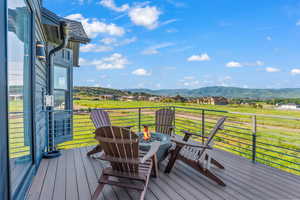 Deck with an outdoor fire pit and a mountain view