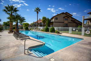 Community pool featuring a residential view, a patio area, and fence