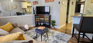 Living room featuring light wood-type flooring, baseboards, and a ceiling fan