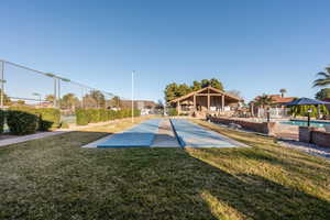 View of property's community featuring fence, a swimming pool, and a lawn