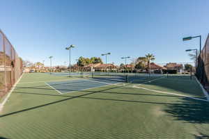 View of tennis court featuring fence