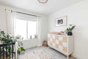 Bedroom featuring light carpet, visible vents, and baseboards