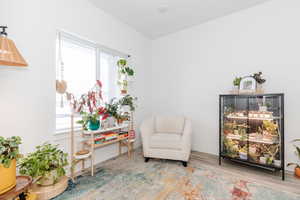 Sitting room featuring a healthy amount of sunlight, baseboards, and wood finished floors