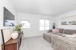 Bedroom featuring light carpet and baseboards