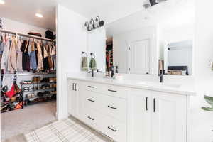 Ensuite bathroom featuring double vanity, a ceiling fan, ensuite bath, a sink, and recessed lighting