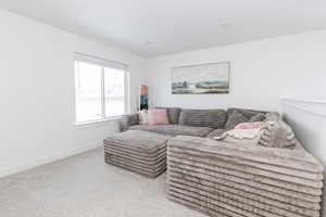 Living room with baseboards and light colored carpet