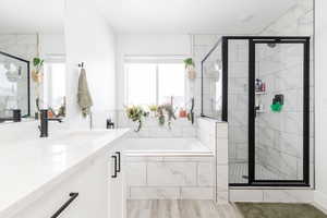 Bathroom featuring vanity, a shower stall, and a bath