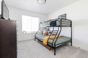 Bedroom featuring baseboards and light colored carpet