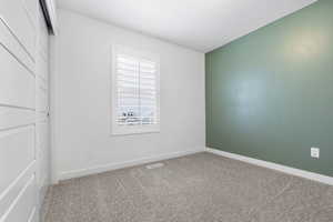 Spare room with carpet flooring, visible vents, and baseboards