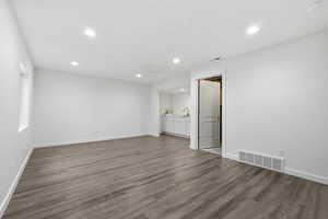 Empty room featuring recessed lighting, visible vents, a sink, and wood finished floors