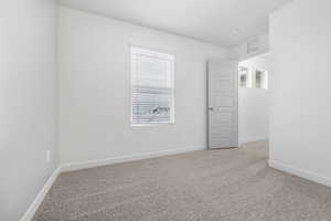 Spare room featuring visible vents, baseboards, and light colored carpet