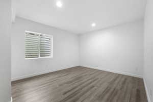 Empty room featuring recessed lighting, wood finished floors, and baseboards