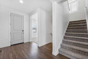 Stairway with wood finished floors and baseboards