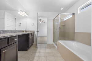 Full bathroom with a stall shower, ceiling fan, vanity, tile patterned flooring, and a bath