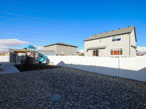 View of yard with a playground and a fenced backyard