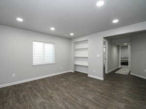 Interior space with baseboards, dark wood finished floors, and recessed lighting