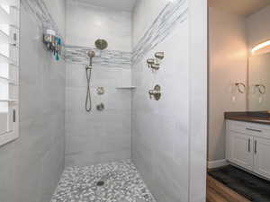 Bathroom with tiled shower and vanity