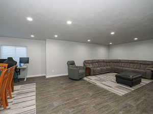 Living room featuring baseboards, wood finished floors, and recessed lighting