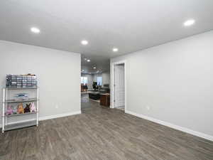 Unfurnished room with dark wood-style floors, baseboards, and recessed lighting