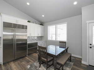 Dining room featuring lofted ceiling, dark wood-type flooring, and recessed lighting