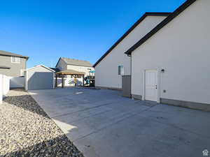 View of side of property with a fenced backyard, an outdoor structure, a gazebo, stucco siding, and a patio area