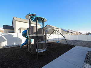 View of play area with a fenced backyard and a residential view