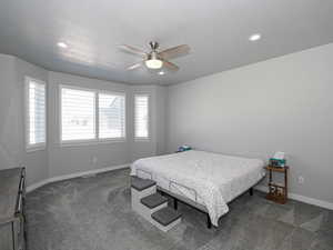 Bedroom featuring baseboards, dark carpet, ceiling fan, and recessed lighting