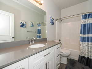 Full bath featuring shower / bath combo, vanity, and toilet