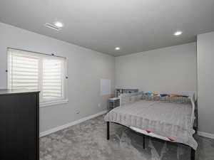 Bedroom with light carpet, baseboards, visible vents, and recessed lighting