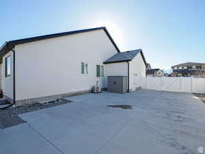 Exterior space with a patio, central AC, fence, a gate, and stucco siding