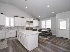 Kitchen with white cabinets, stainless steel appliances, pendant lighting, and light countertops