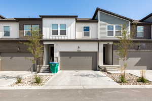 Townhome / multi-family property featuring driveway, an attached garage, and board and batten siding