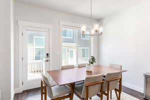 Dining area with an inviting chandelier, dark wood finished floors, and baseboards