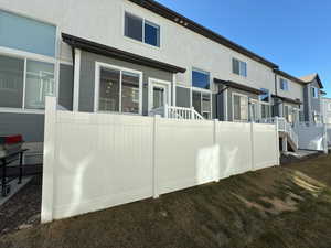 Back of house featuring a wooden deck and stucco siding