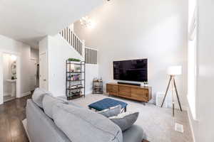 Living room featuring a chandelier, visible vents, and baseboards