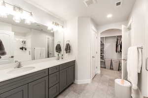 Bathroom featuring double vanity, a sink, and visible vents