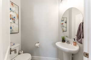 Bathroom featuring baseboards, a sink, and toilet