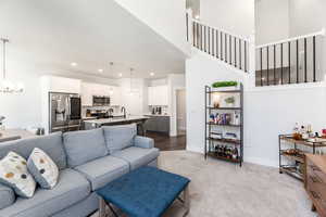 Living room with carpet, recessed lighting, baseboards, and an inviting chandelier