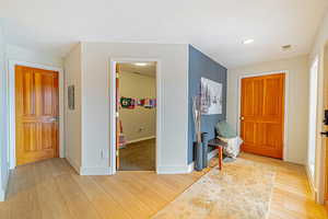 Entrance foyer with light wood finished floors, visible vents, and baseboards