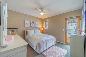 Carpeted bedroom with access to exterior, ceiling fan, and baseboards