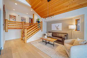 Living area with light wood-style flooring, recessed lighting, wood ceiling, baseboards, and vaulted ceiling