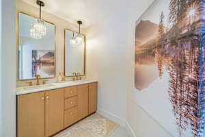 Full bathroom featuring tile patterned flooring, a sink, baseboards, and double vanity