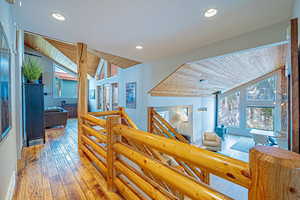 Hall featuring vaulted ceiling, wood ceiling, hardwood / wood-style flooring, and recessed lighting